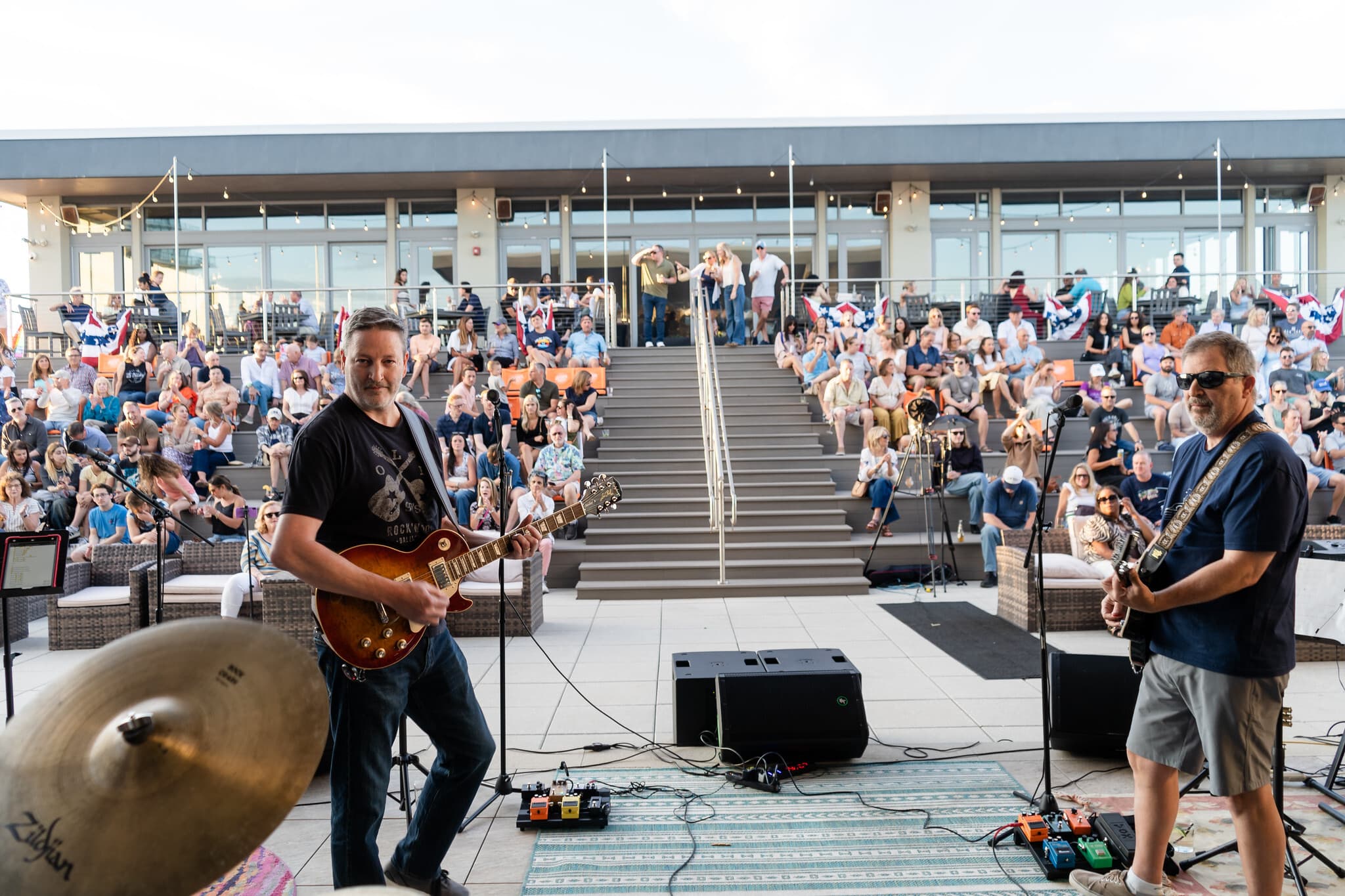 Guitarists performing a rooftop concert at golden hour